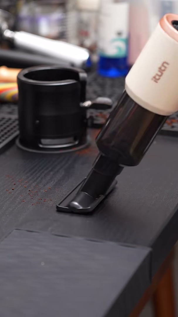 Y8 Plus vacuuming coffee grounds from a dark desk